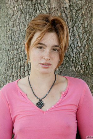 Seductive red teen in jeans shorts posing outdoors