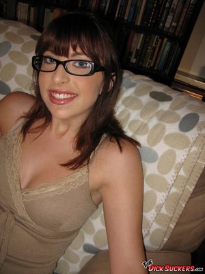 Nerdy brunette sucks a big shaft on the couch.