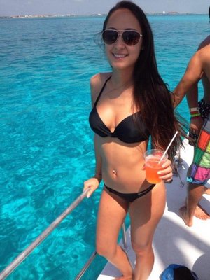 Black-haired girl is posing in bikini on the boat