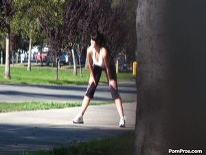 The camera watches from a distance, as this petite runner stretches