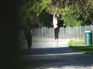 The camera watches from a distance, as this petite runner stretches