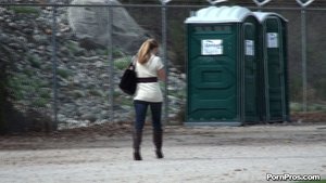 Golden locks secured in a ponytail, she struts right up to a porta-potty