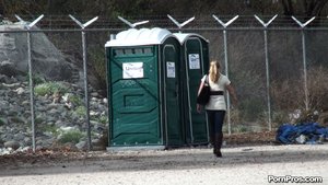 Golden locks secured in a ponytail, she struts right up to a porta-potty