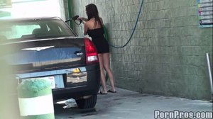 Wearing a very tight, little, black dress, this brunette washes a car