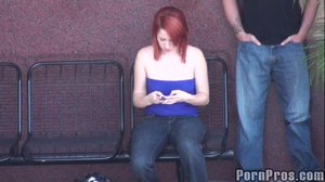 Wearing a blue tube top and jeans, this sexy whore sits in a public place