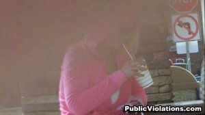 Blonde, in a pink hoodie, she gets splashed while texting on her phone