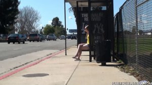 Petite, in yellow, with flip flops and shades, she waits on the bus bench