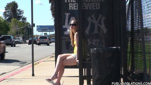 Petite, in yellow, with flip flops and shades, she waits on the bus bench
