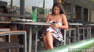 Hanging out in a public place, she plays on her phone while wearing a dress