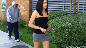 Sporting a tight black tube top and a tiny skirt, this brunette gets followed