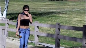 Wandering through a park, this tramp in black gets filmed as she struts around